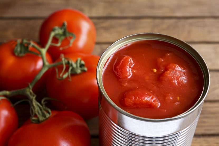 Conserve de tomates à côté de tomates fraîches