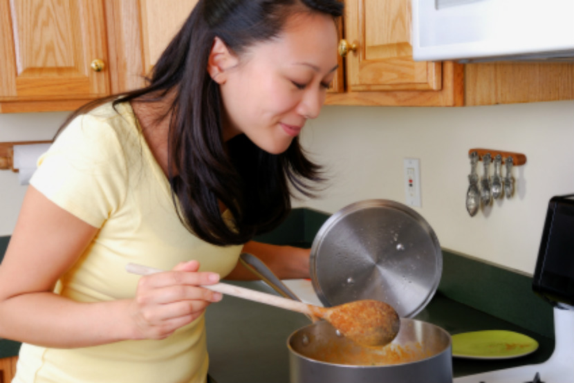 woman cooking something in a pot on the stove