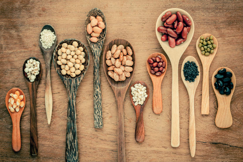 wooden spoons with various legumes on them