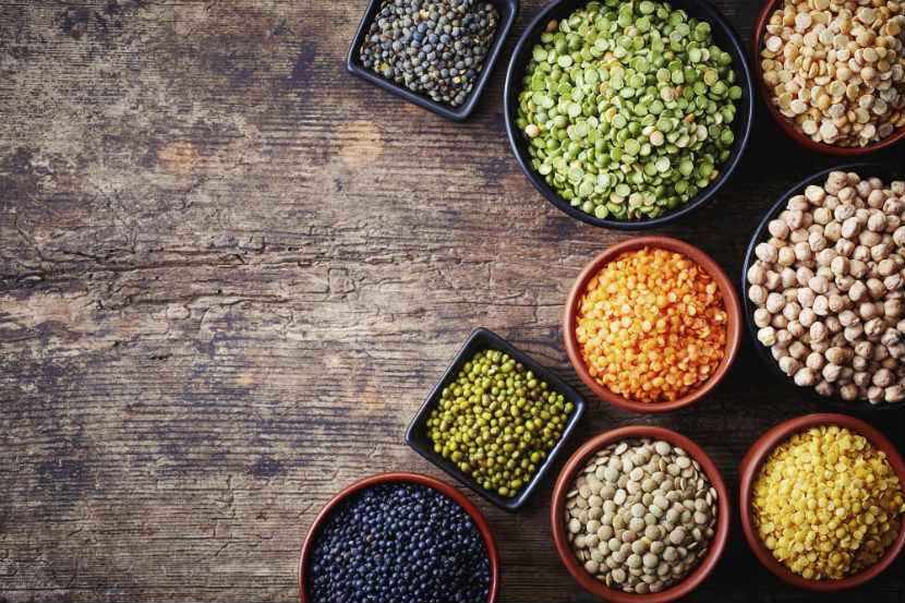 legumes, split peas, lentils, black beans and chickpeas in bowls on a table.