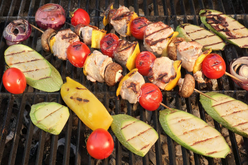 meat and vegetable kebabs being cooked on a bbq