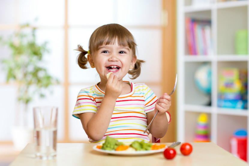 happy toddler girl eating a meal