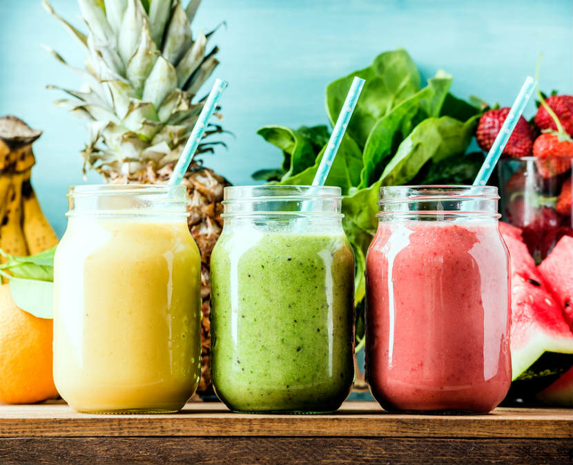 Fruit smoothies in glass jars with straws